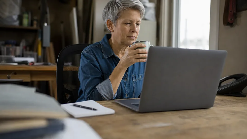 Owner of a small contracting firm reading the morning bid alerts at her office desk